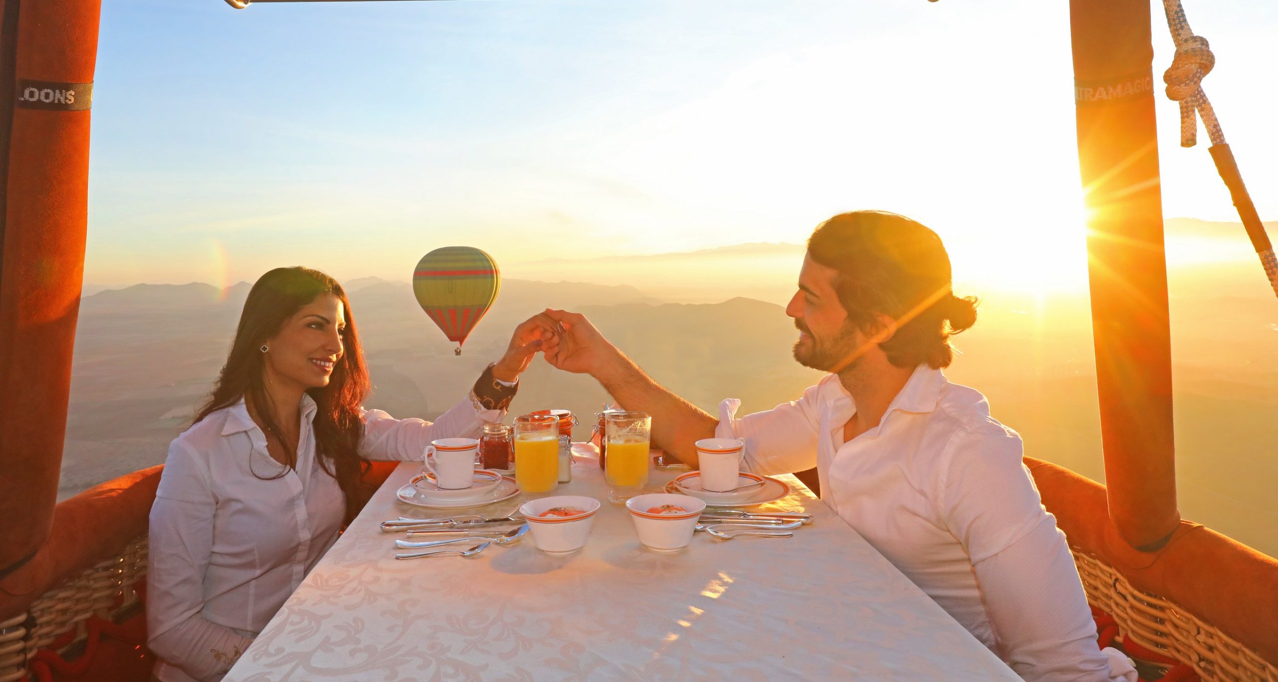 Hot air balloon rising over the Marrakech countryside at sunrise