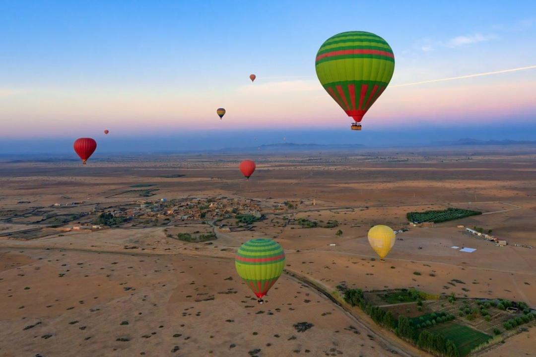 Hot air balloon drifting above the plains outside Marrakech at sunrise