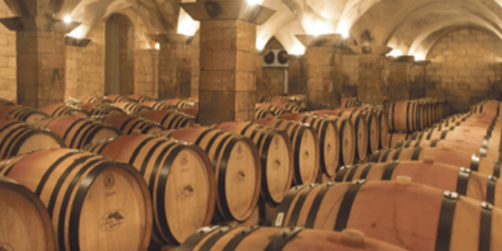Rows of oak barrels under a vaulted ceiling