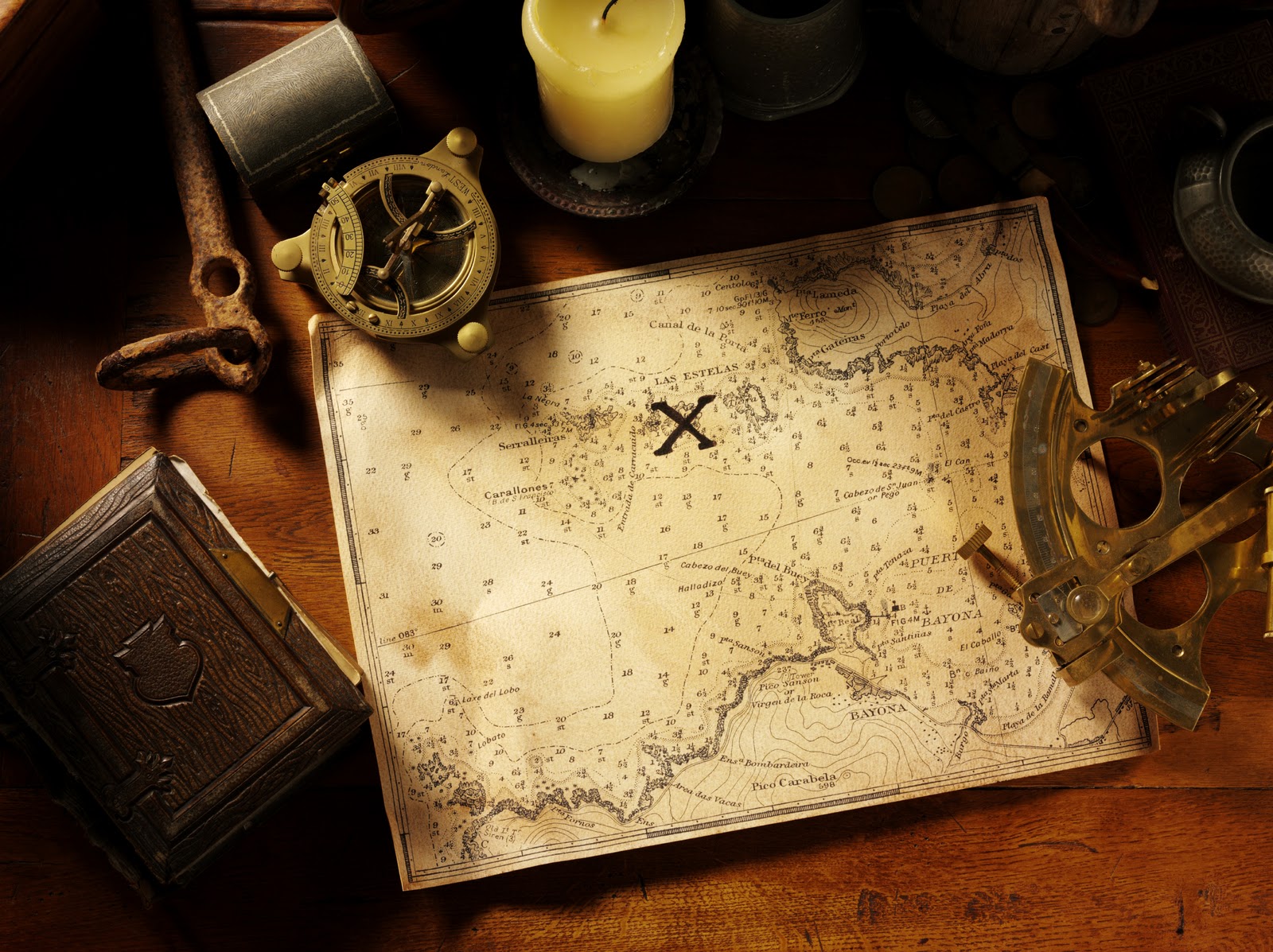 Hand-drawn treasure map marked with a cross beside a brass compass